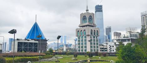 A cityscape with modern buildings, a blue-domed structure, and a park area with pathways.