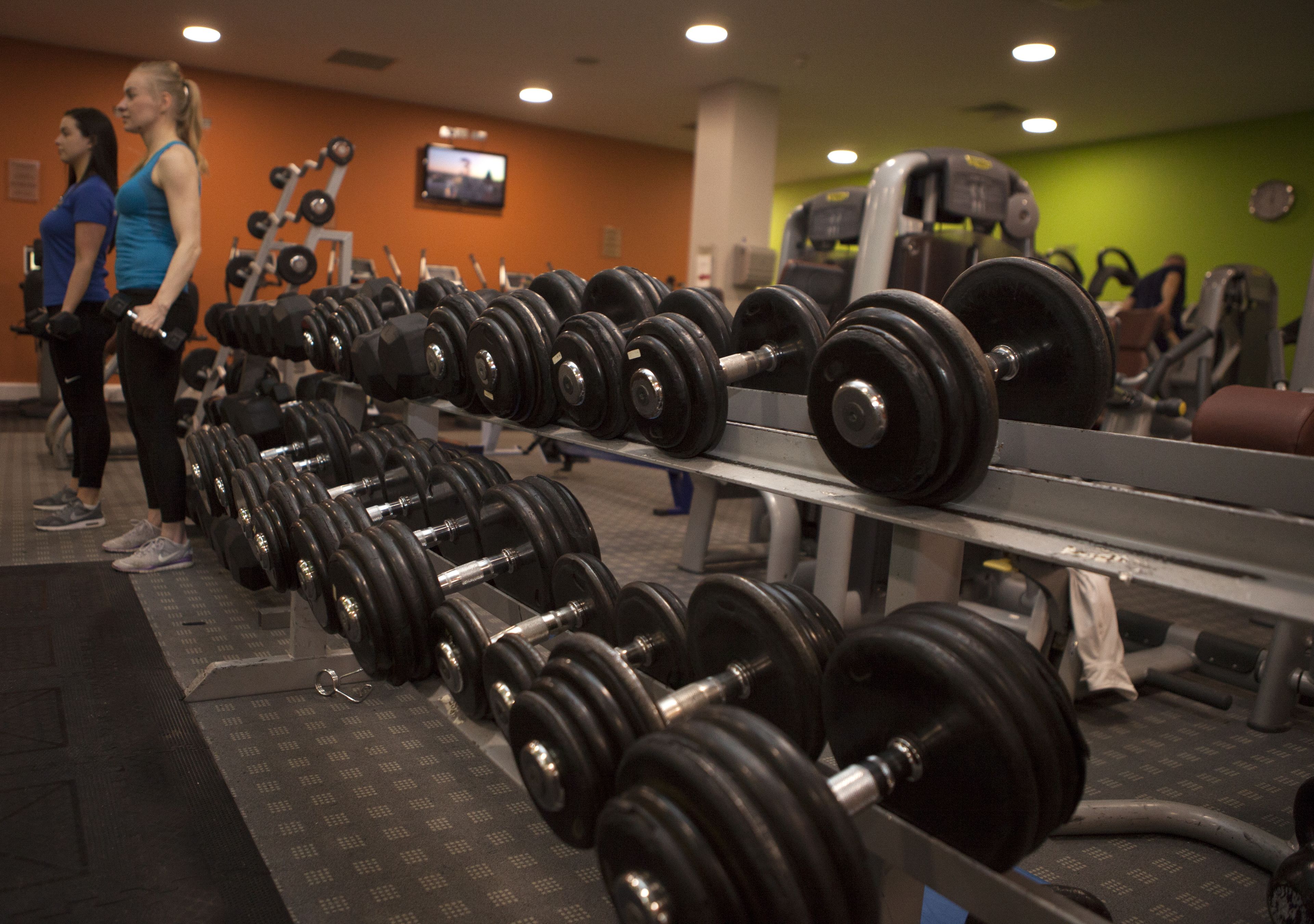 Une salle de sport avec des rangées d’haltères et d’appareils de musculation.