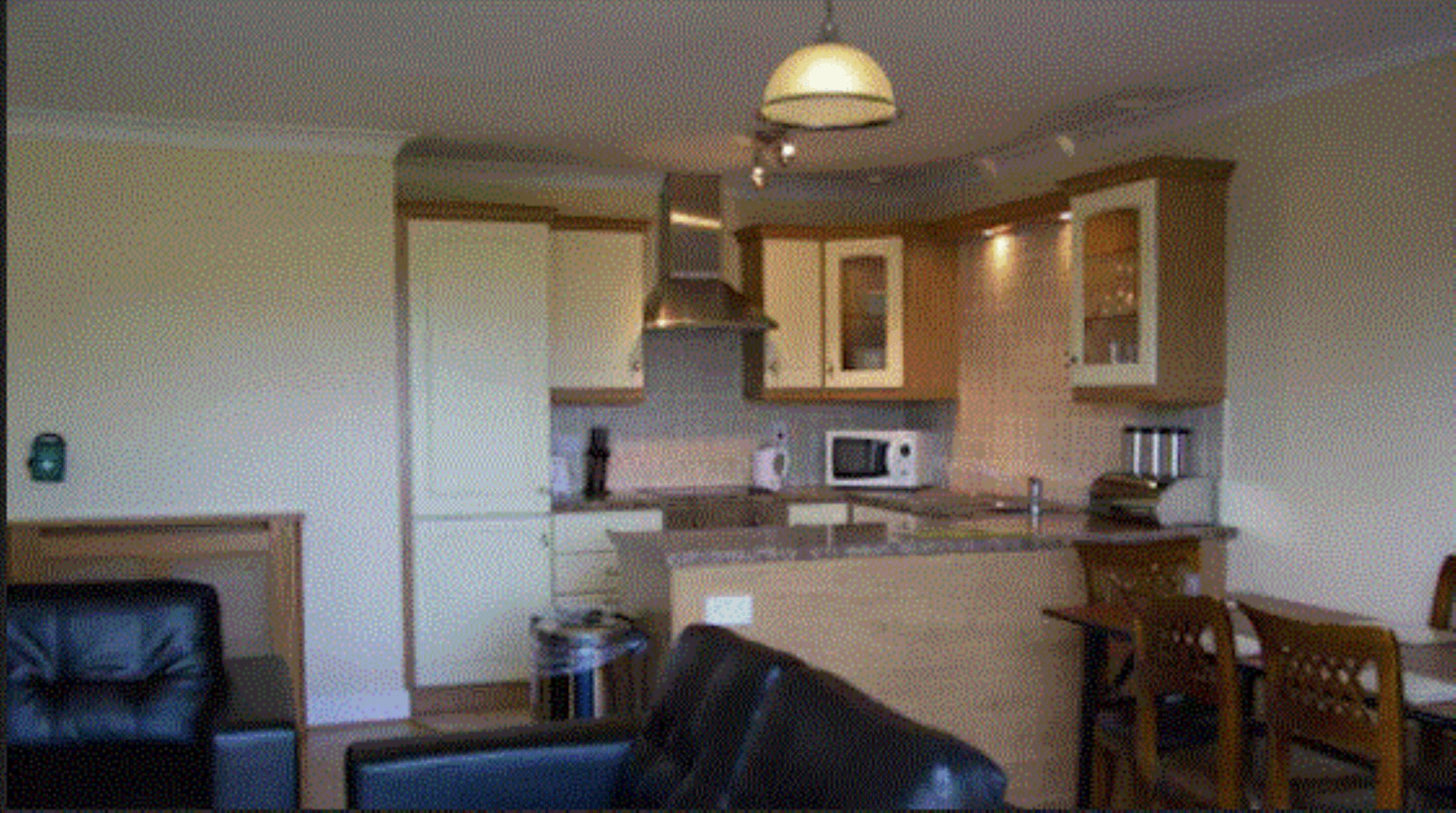 A compact living space with a kitchenette, a dining area, and a seating area.