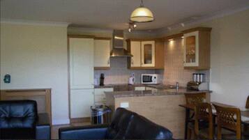 A compact living space with a kitchenette, a dining area, and a seating area.