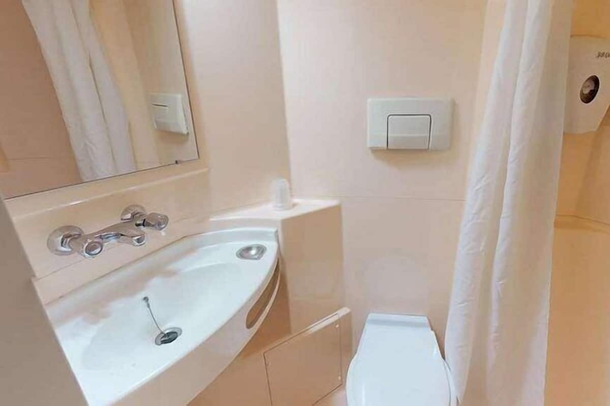 A bathroom with a sink, mirror, and toilet.