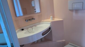 Un bagno piccolo con lavandino, specchio e water.