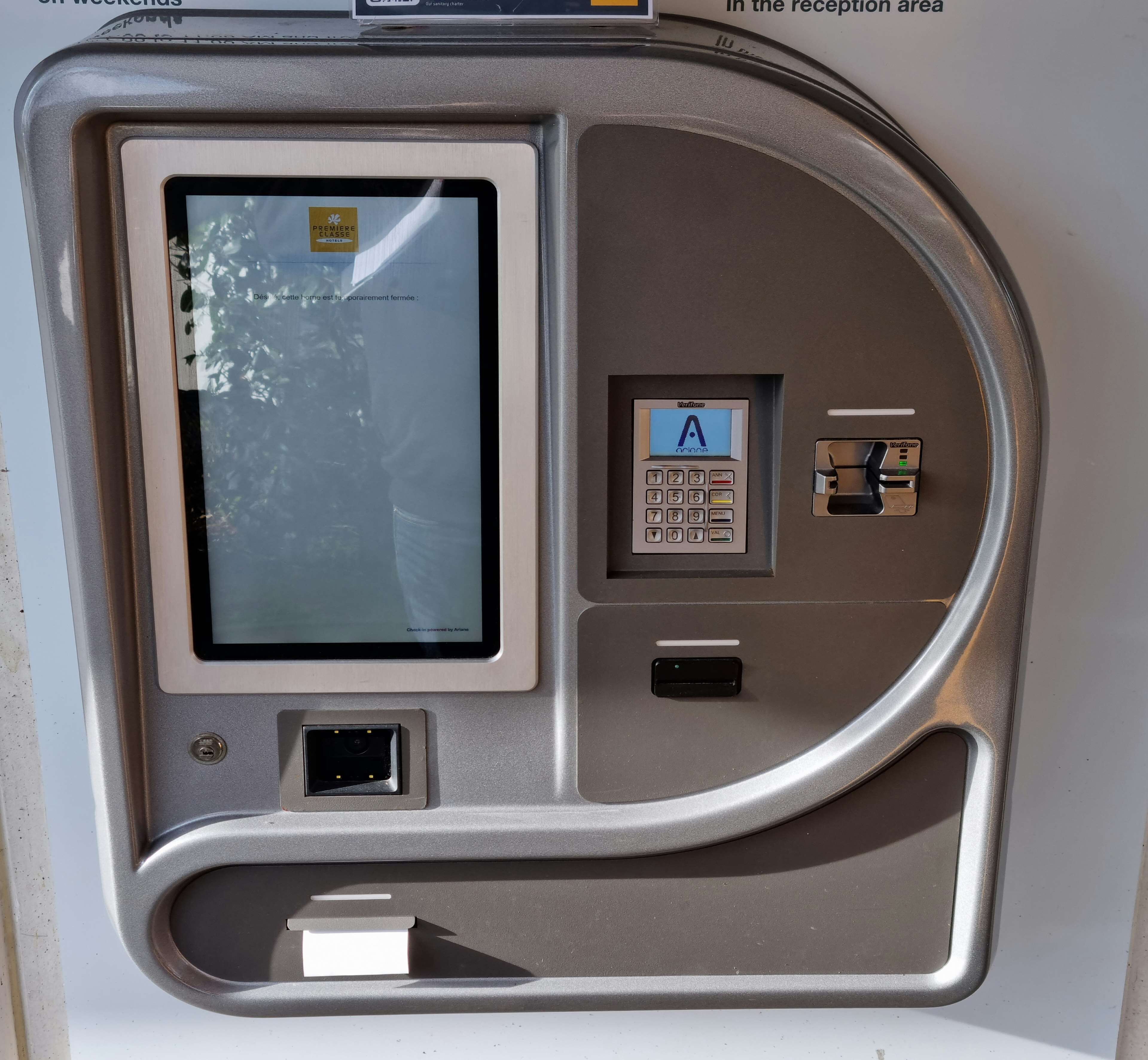 A self-service kiosk with a screen, keypad, and card reader, likely for check-in or payment.