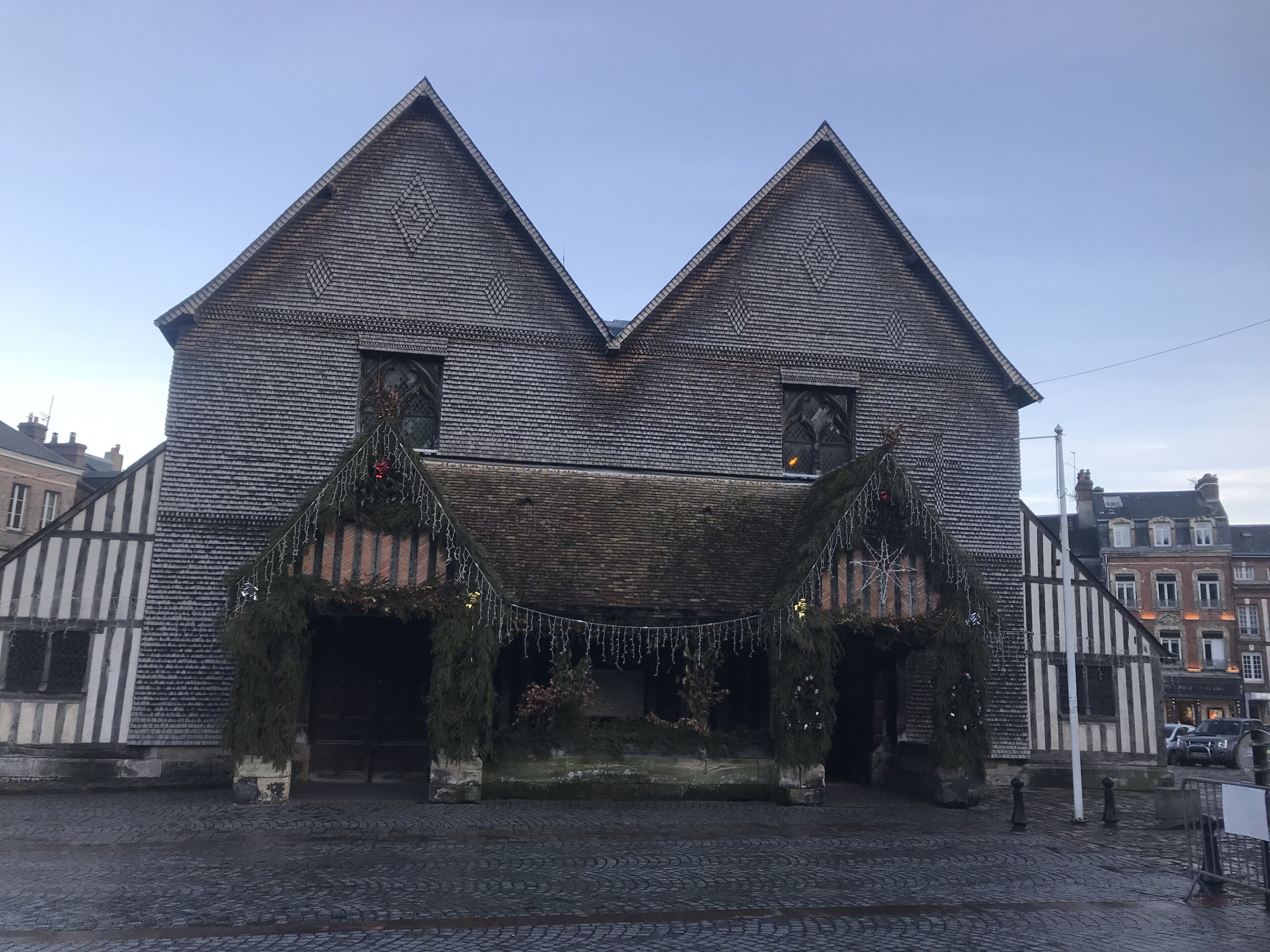 A traditional building with a symmetrical facade, featuring a central entrance with a decorative archway and hanging lights.