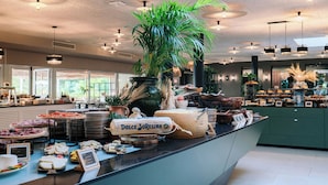 A buffet area with various food items, a large green plant, and a sign reading "Dolce Soreseina". - Mangia's Brucoli, Sicily, Autograph Collection (Augusta)