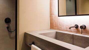A bathroom with a large sink, a mirror, and a towel rack.