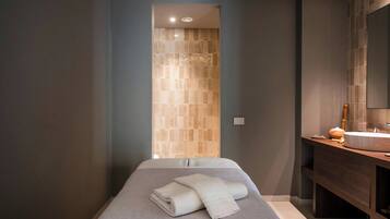 Un baño moderno con un espejo grande, un mueble de tocador de madera y una toalla en el suelo.