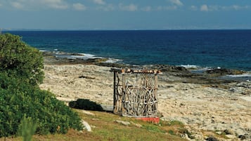 Een rotsachtige kust met een houten constructie en uitzicht op de oceaan.