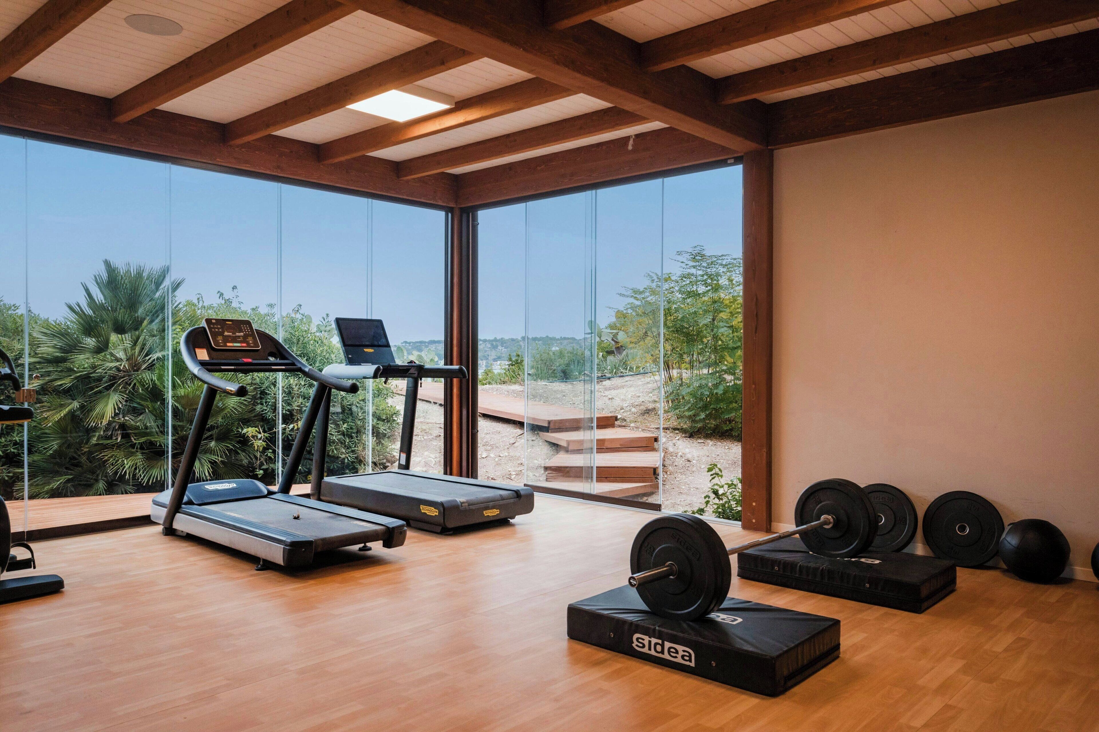 Ein modernes Fitnessstudio mit Laufbändern, Fahrrädern und Gewichten.