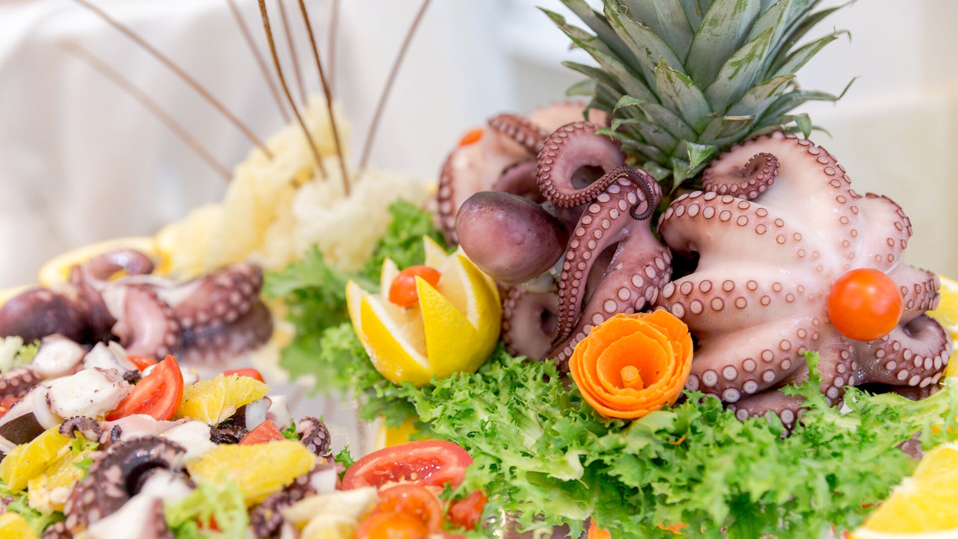 Een visplateau met oktopus tentakels, citroenpartjes, kerstomaatjes en een ananas.