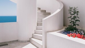 A spiral staircase with white walls and a view of the sea. - Mangia's Torre del Barone Resort and SPA (Sciacca)