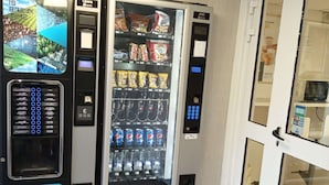 A vending machine with various snacks and drinks, a payment terminal, and a digital display. - Premiere Classe Saint Brice Sous Forêt (Saint-Brice-sous-Foret)