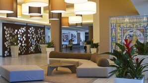 A spacious lobby with a large seating area, decorative wall panels, and a tiled mosaic artwork. - MClub Lipari (Sciacca)
