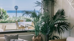 Cómoda sala de estar con mobiliario de mimbre, una mesa de centro de vidrio y vista al mar.