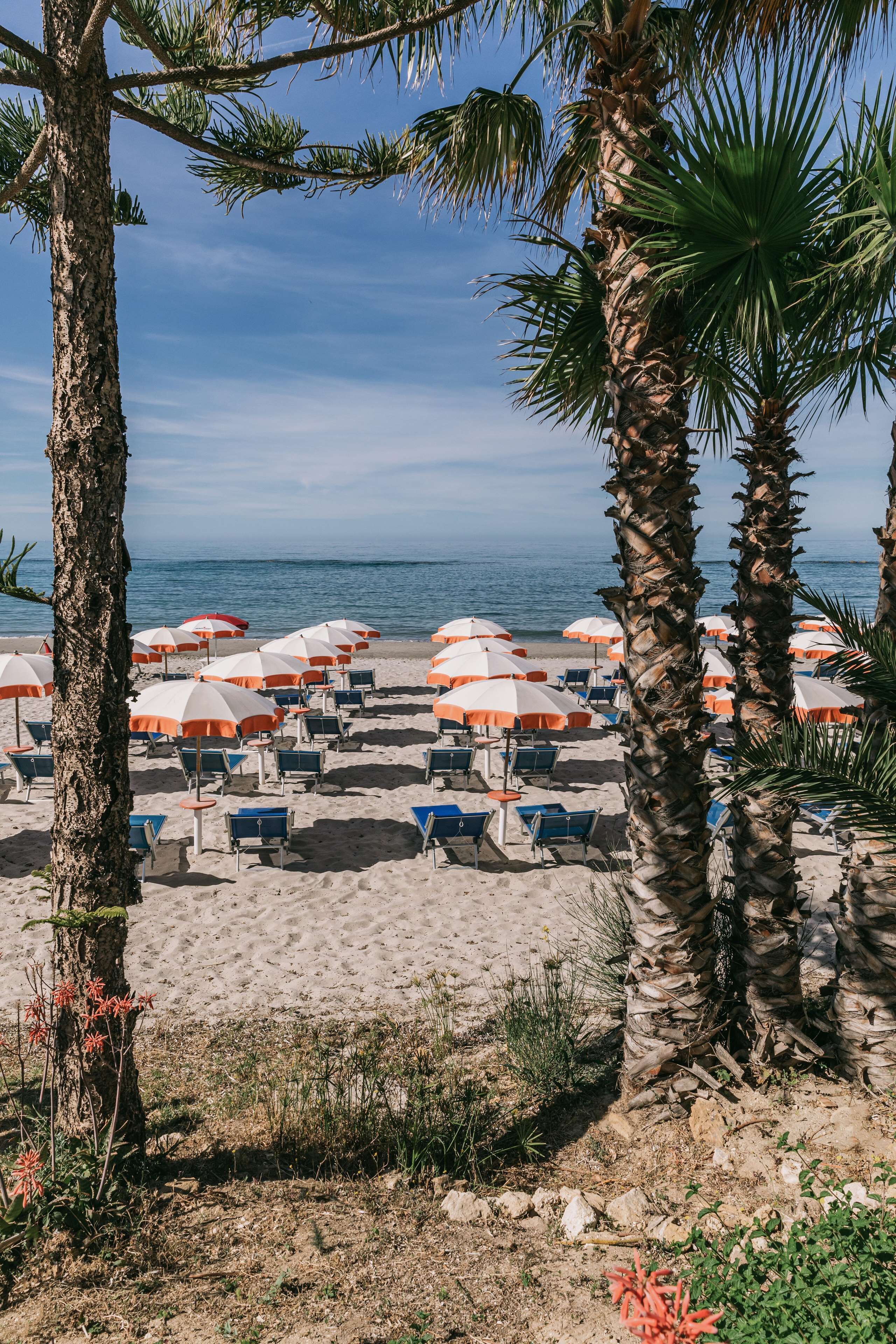 Playa privada, sillas reclinables de playa, sombrillas
