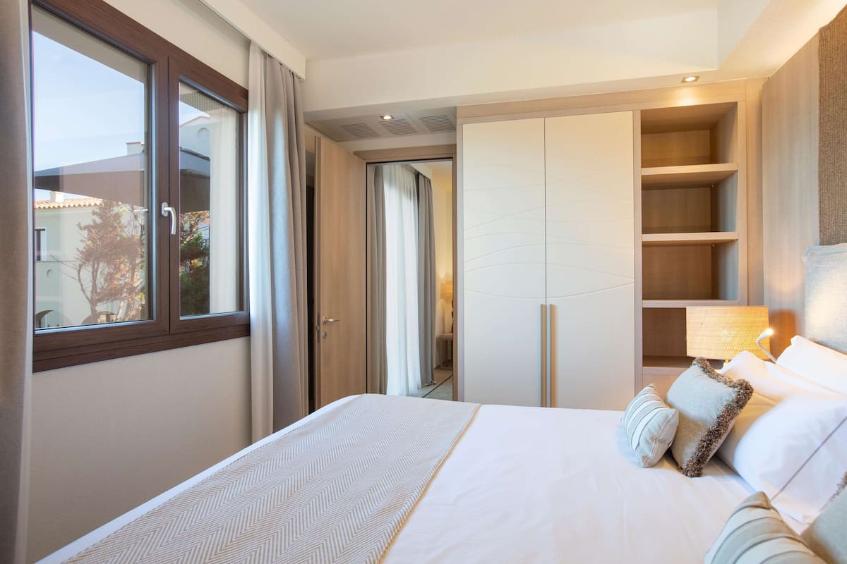 Un dormitorio con una cama grande, un armario y una ventana.