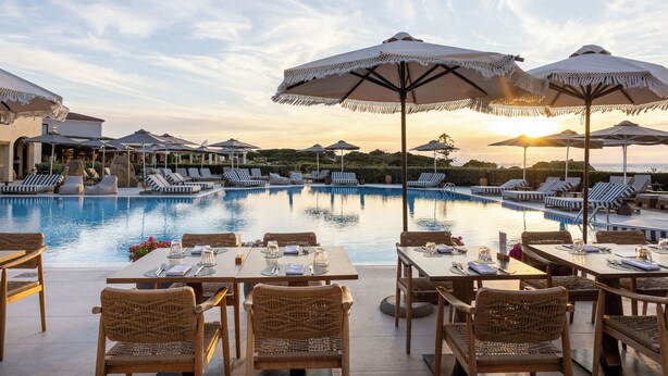 A poolside dining area with tables and chairs, umbrellas, and lounge chairs. - Mangia's Santa Teresa Sardinia, Curio Collection by Hilton (Santa Teresa di Gallura)