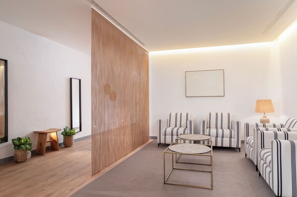 Un salon moderne comprenant un ensemble de canapés, une table basse et un petit tabouret en bois.
