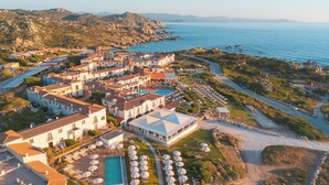 Ein Küstenresort mit mehreren Villen, einem Pool und einem Strandbereich.