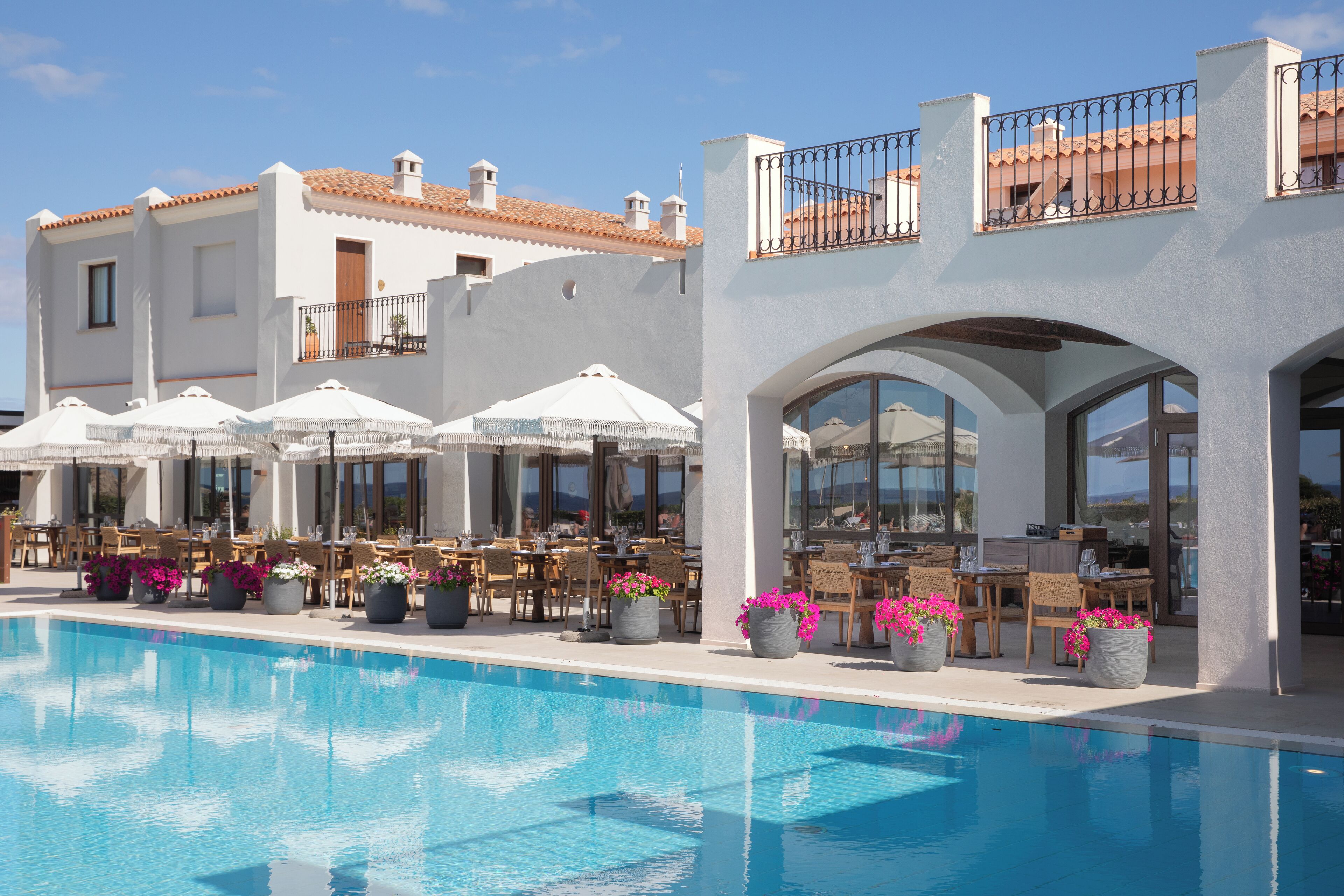 Zona junto a la piscina con mobiliario exterior y vista despejada del agua.