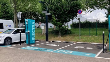 Park and charge your vehicle in a designated area surrounded by lush greenery.