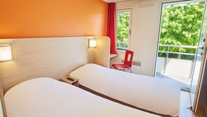 A hotel room with two beds, a red chair, a window with a view of greenery, and a door leading to an outdoor balcony. - Hôtel Premiere Classe Melun Senart - Vert Saint Denis (Vert-Saint-Denis)