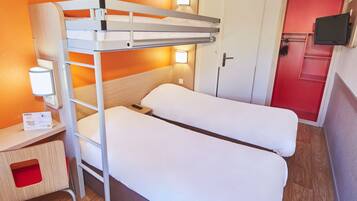 A bunk bed room with a desk, a TV, and a door with a red panel.