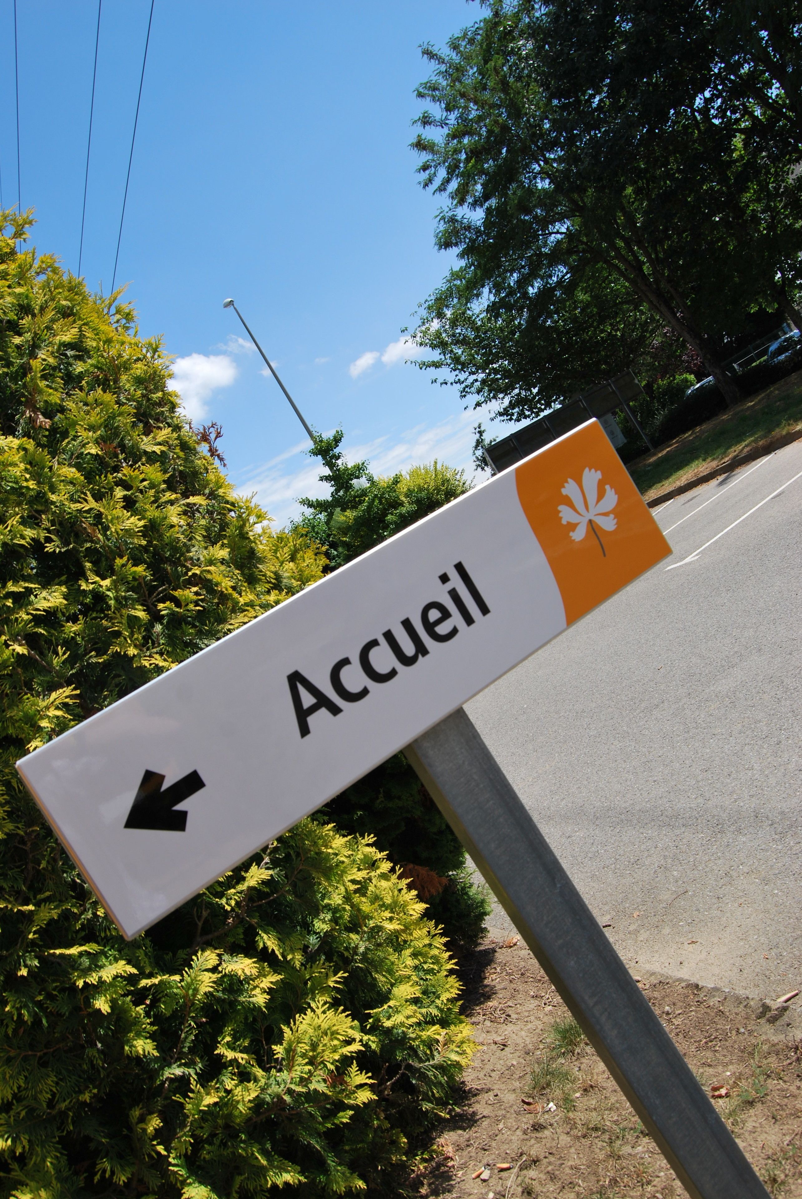 A directional sign with the word "Accueil" and an arrow pointing left.