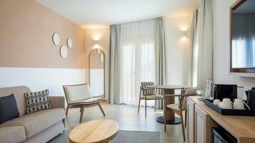 Ein modernes Wohnzimmer mit einer Couch, Sesseln, einem Couchtisch, einem Esstisch und einem Fernseher.