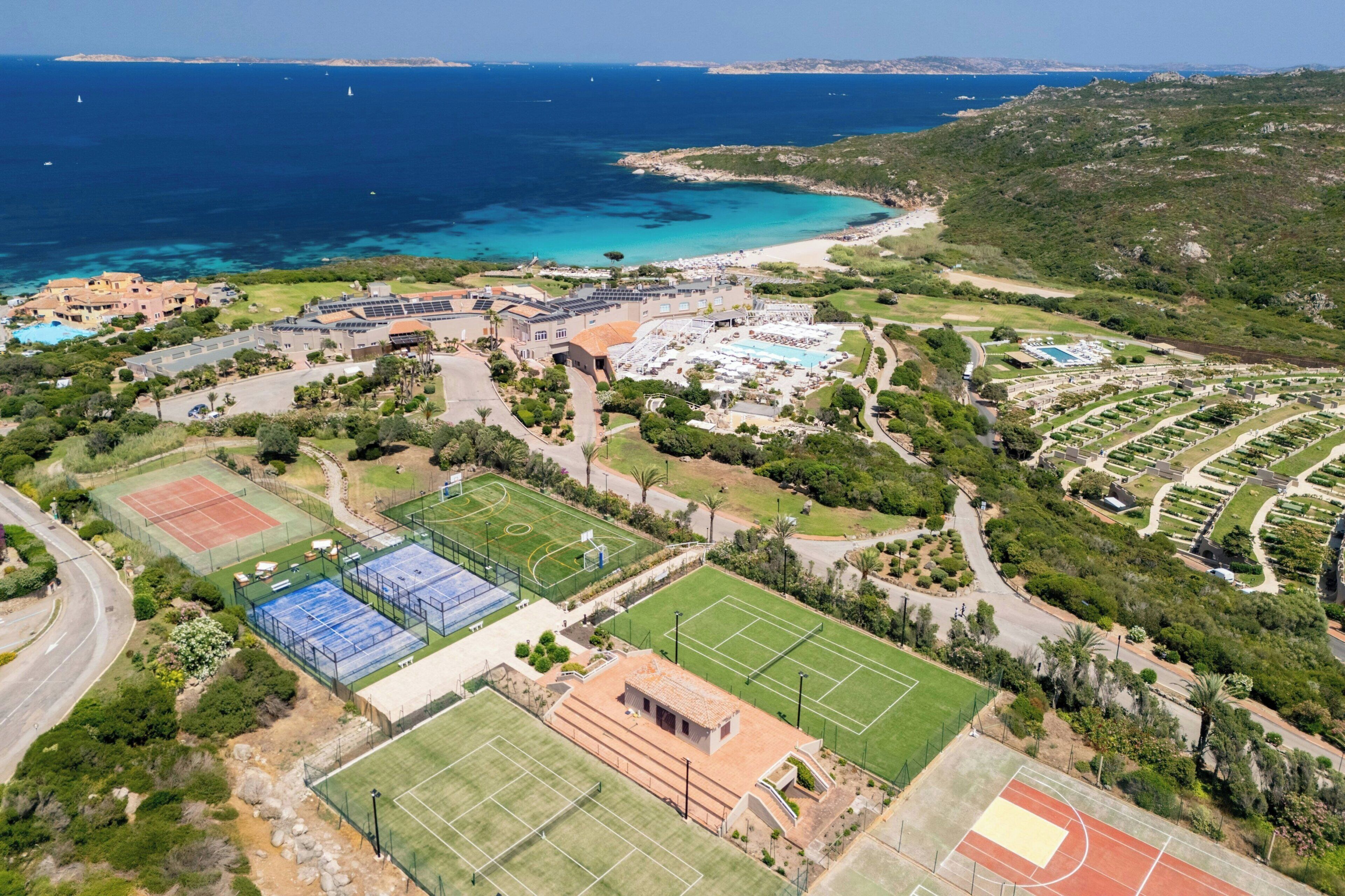 Vue aérienne d’une station balnéaire dotée de plusieurs courts de tennis, d’une piscine et d’une plage.