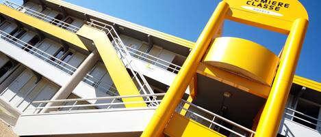 Un edificio amarillo y blanco con un letrero que dice 'Premiere Classe Hotels'.