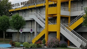 Un hôtel doté d’une façade jaune et grise bien visible, de plusieurs escaliers et d’une enseigne indiquant qu’il s’agit d’un hôtel Premier Classe.