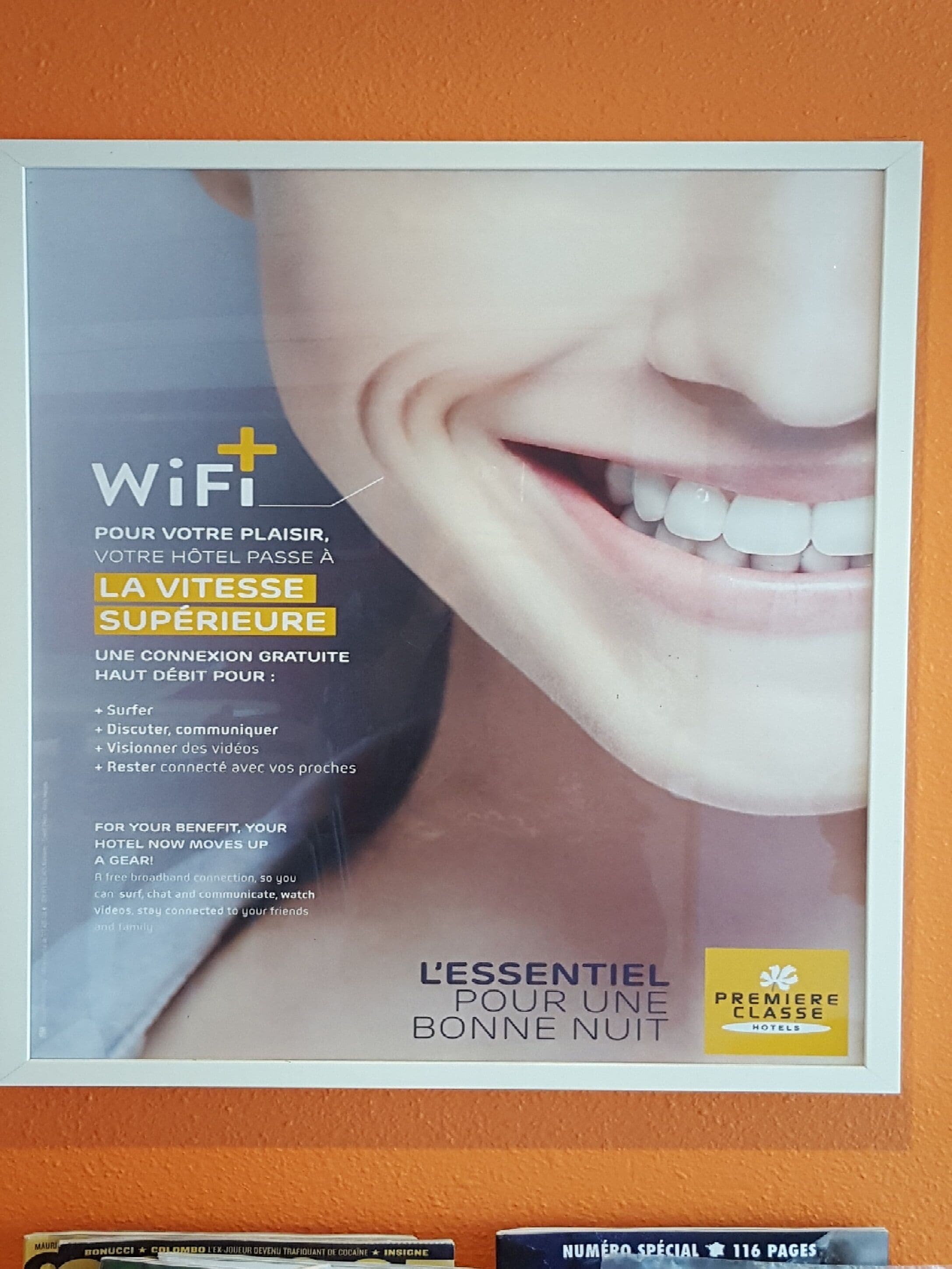 En indrammet reklame for et hotel, der viser en smilende kvinde, og fremhæver gratis WiFi og andre faciliteter.