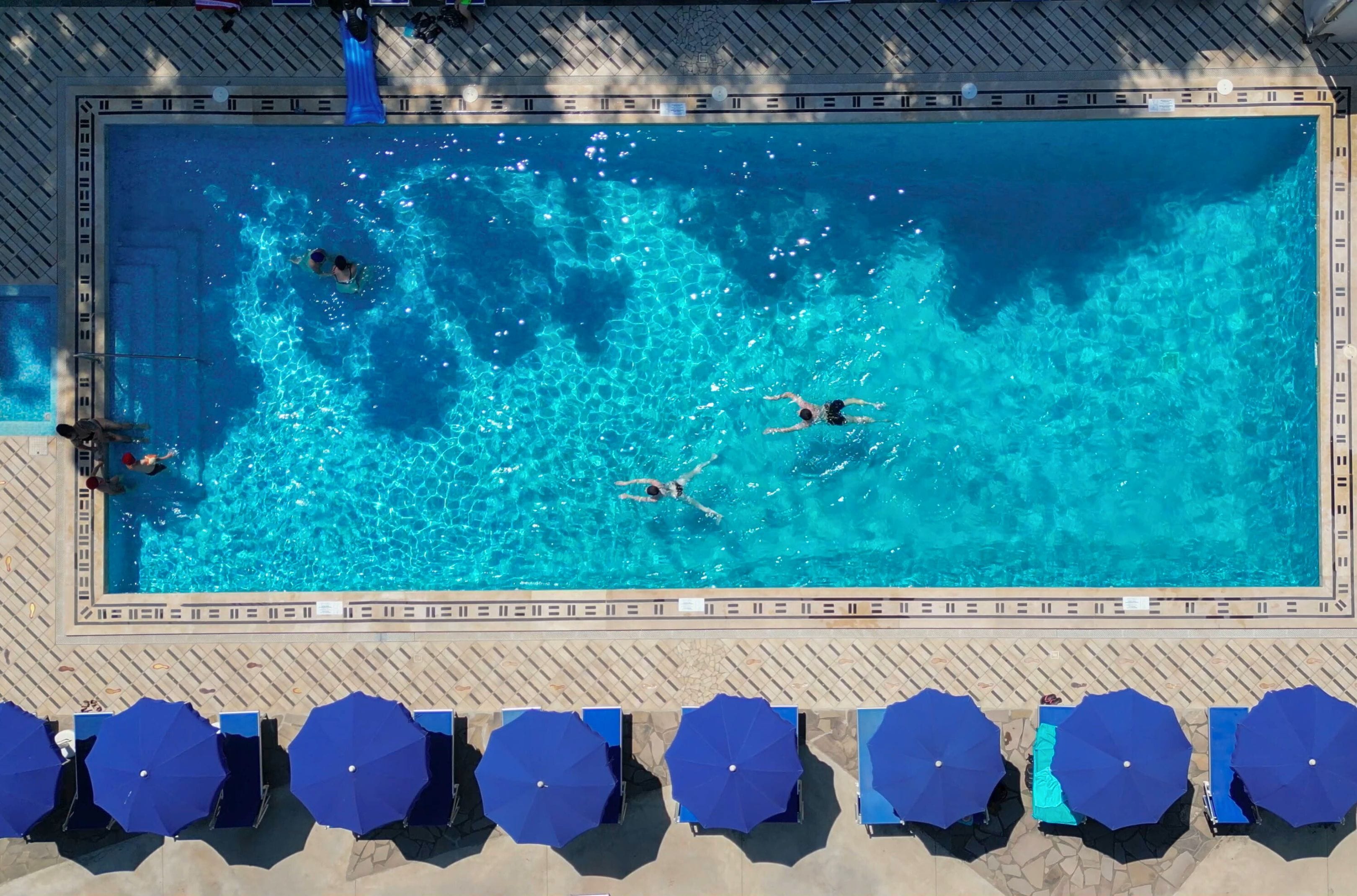 Alberca al aire libre, sombrillas en la alberca y camastros 