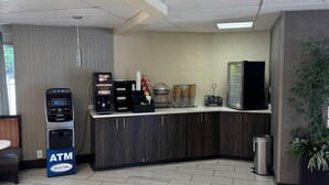 A modern kitchen area with a built-in microwave, a refrigerator, and a coffee machine. - Gallus Stadium Park Inn, an Ascend Collection Hotel (Columbia)