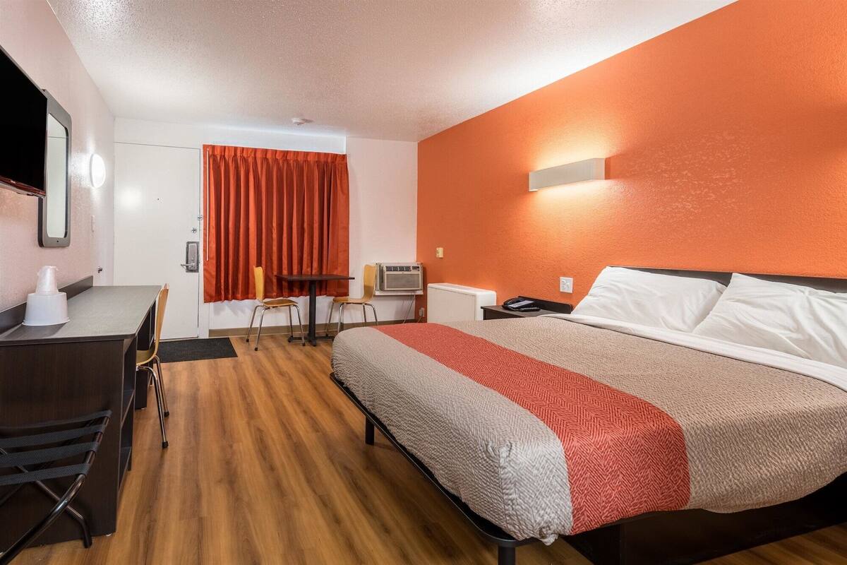 Une chambre d’hôtel avec un lit, un bureau et une chaise.