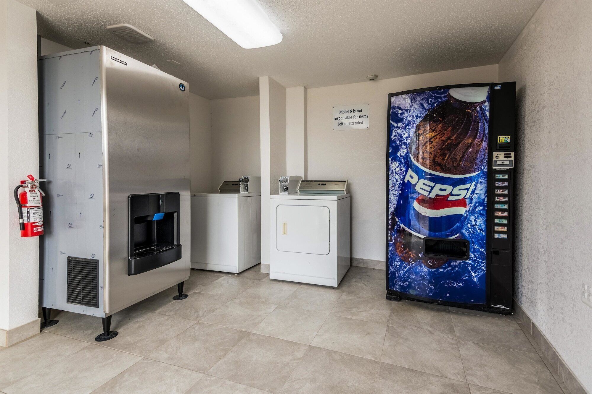 A kitchenette area with a refrigerator, a microwave, a water dispenser, a small freezer, and a vending machine.