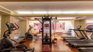 Un gimnasio con cintas de correr, elípticas y máquinas de pesas.