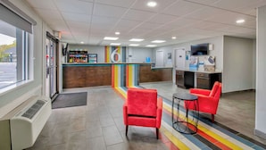 A reception area with a counter, a TV, and seating.