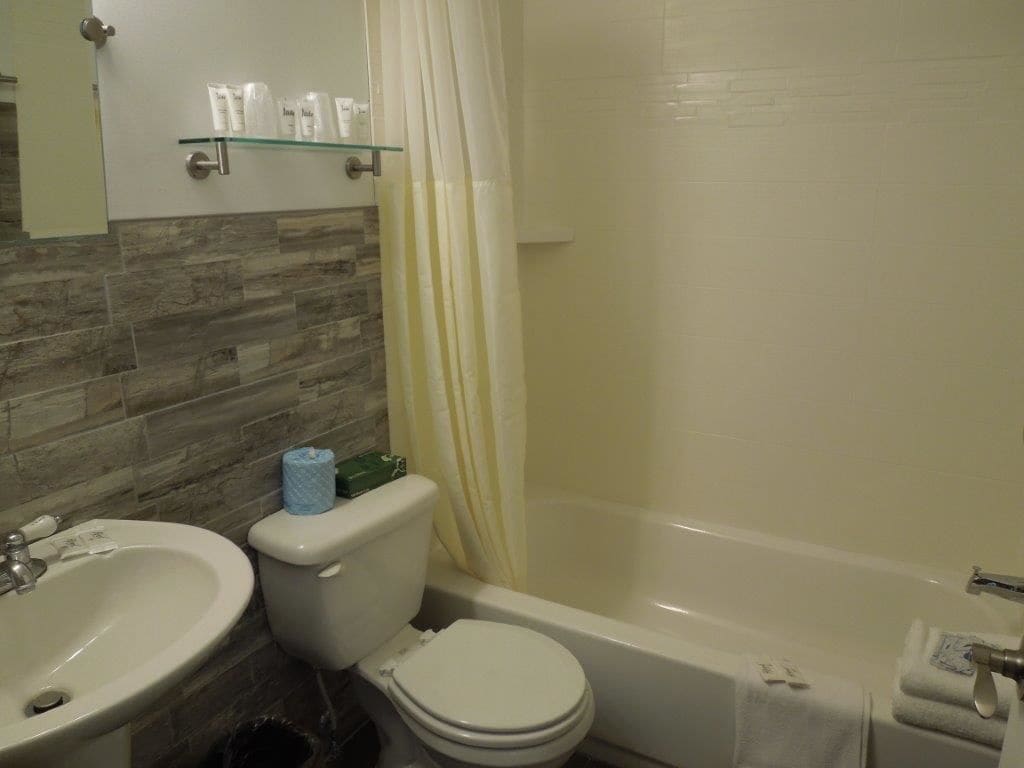 A bathroom with a toilet, sink, and bathtub.
