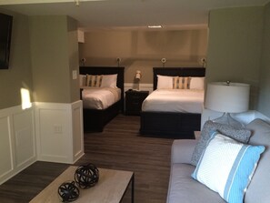 A hotel room with two beds, a sofa, a lamp, and a coffee table. - Super 8 by Wyndham Albany (Albany)