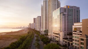 Un hôtel de grande hauteur, avec de nombreux étages, un grand chiffre « 8 » bien visible sur la façade et une enseigne « Golden Screen Cinemas ».