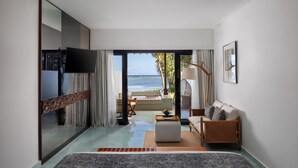 A modern hotel room with a large bed, a sofa, a TV, and a view of the sea. - Sadara Resort (Nusa Dua)