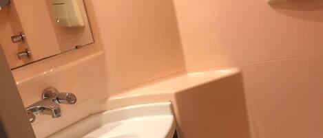 Une salle de bain avec un lavabo, un miroir et des toilettes.