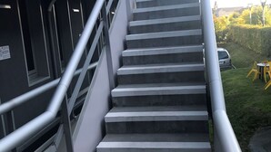 A staircase with metal railings leading to a building entrance. - Première Classe Saint Malo - Saint Jouan des Guérets (Saint-Jouan-des-Guerets)