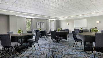 A conference room with a geometric patterned carpet, round tables, and chairs.