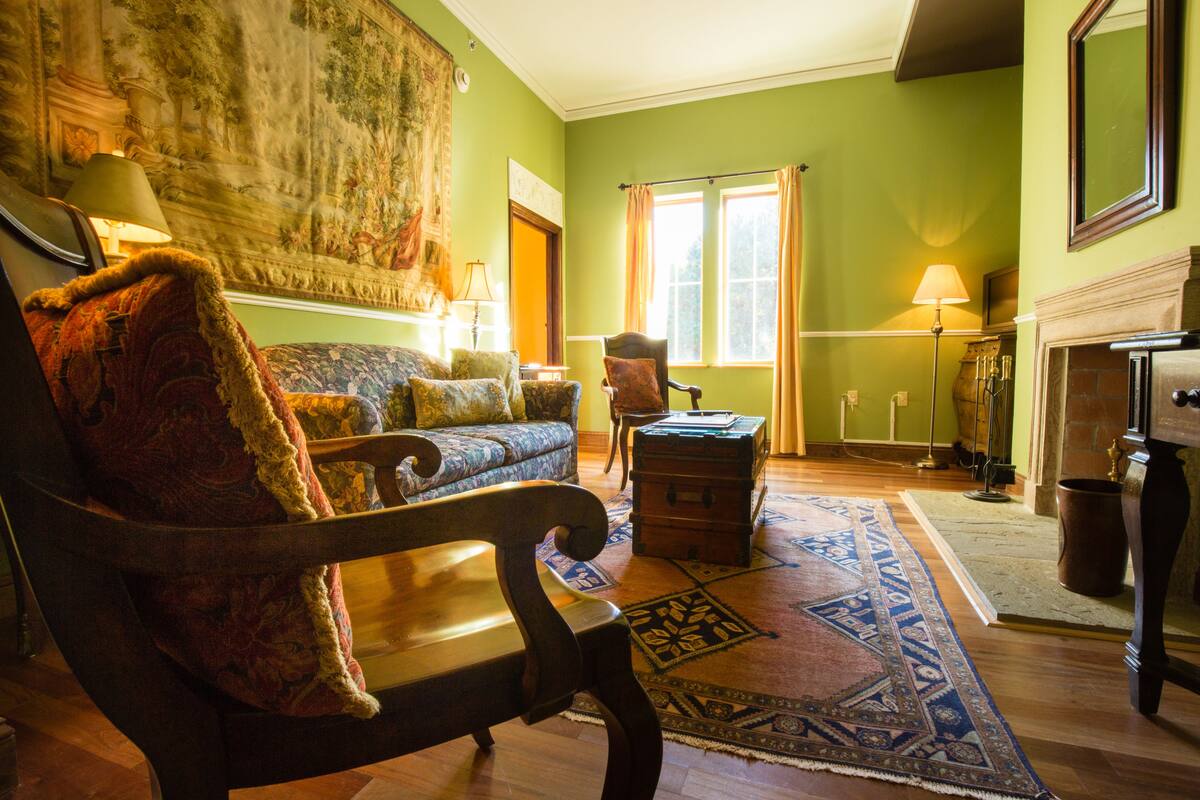 A traditional living room with a sofa, armchair, and a fireplace.