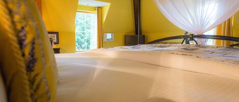 Un dormitorio con cama, ventana y cortina.