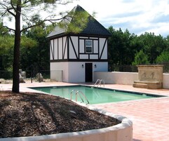 Una piscina al aire libre de temporada, sombrillas, tumbonas