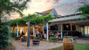 An outdoor patio area with seating, potted plants, and a bar area. - Wedmore Place (Williamsburg)